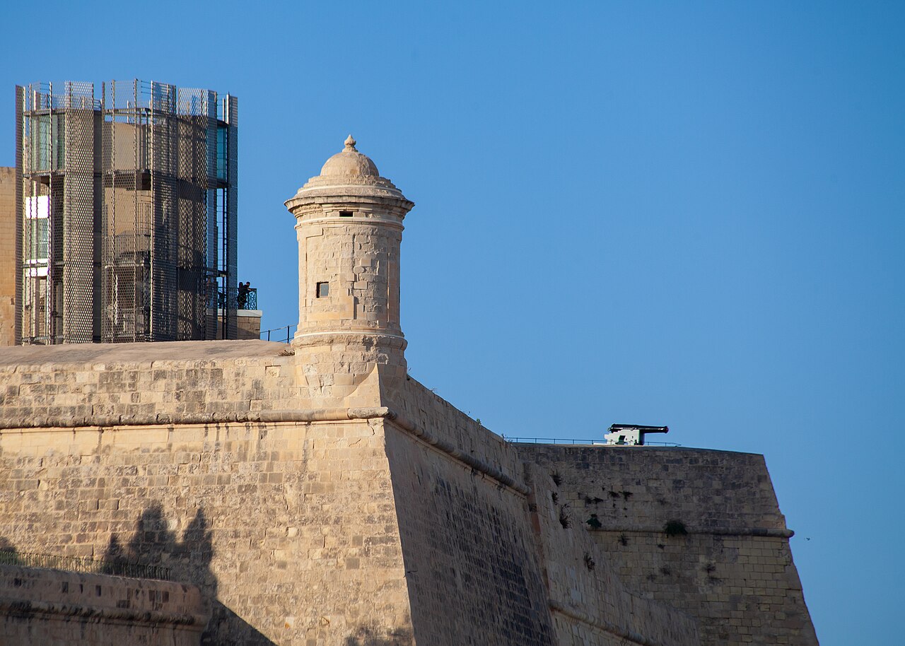 The modern Barrakka Lift beside Valletta’s historic fortifications